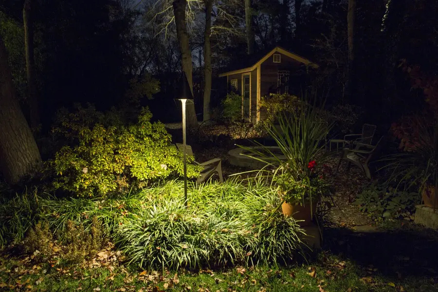 an outdoor area at night with a tall garden light.